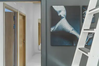 a room with a painting on the wall next to a ladder at Grey House in Vilnius