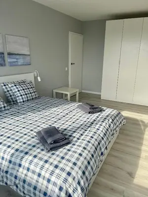 a bedroom with a bed with a blue and white plaid blanket at panoramic view and free parking in Vilnius