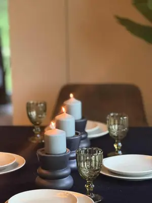 a table with candles and plates and glasses on it at Vila Forest Resort in Kvietkučiai
