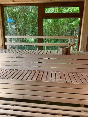 a large wooden bench in a room with a window at Vila Forest Resort in Kvietkučiai