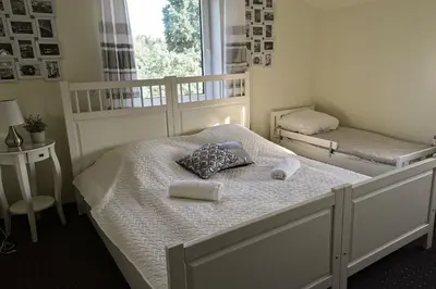 a bedroom with two beds with towels and a window at Vila Forest Resort in Kvietkučiai