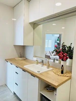 a white kitchen with a sink and a mirror at Butas pačiame Šiaulių miesto centre in Šiauliai