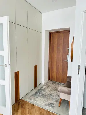 a living room with a door and a chair at Butas pačiame Šiaulių miesto centre in Šiauliai