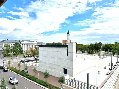 a large white building with a clock tower in a city at Butas pačiame Šiaulių miesto centre in Šiauliai