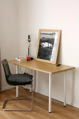 a desk with a picture and a chair at Naujai suremontuotas butas miesto centre. in Visaginas