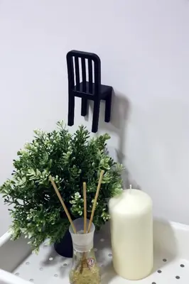 a candle and a chair and a plant on a table at Naujai suremontuotas butas miesto centre. in Visaginas