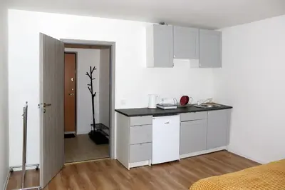 a kitchen with white cabinets and a black counter top at Naujai suremontuotas butas miesto centre. in Visaginas