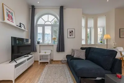 a living room with a blue couch and a tv at Freedom avenue apartment by Polo Apartments in Kaunas