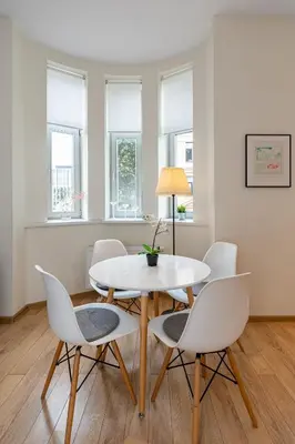 a dining room with a white table and chairs at Freedom avenue apartment by Polo Apartments in Kaunas