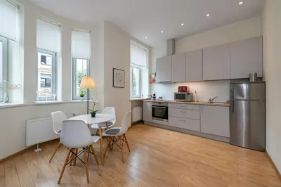 a kitchen with white cabinets and a table and chairs at Freedom avenue apartment by Polo Apartments in Kaunas