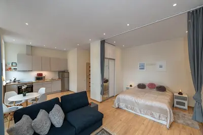 a living room with a bed and a kitchen at Freedom avenue apartment by Polo Apartments in Kaunas