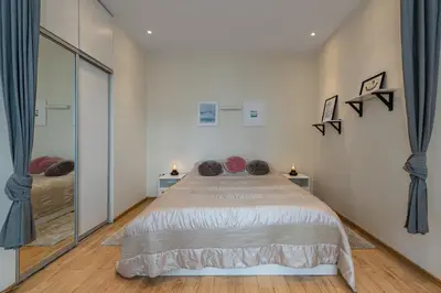 a bedroom with a bed and a large mirror at Freedom avenue apartment by Polo Apartments in Kaunas