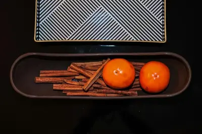 two tomatoes and cinnamon sticks in a tray with a box at #stayhere - Spacious Luxury Town Hall 3BDR Apartment in Vilnius