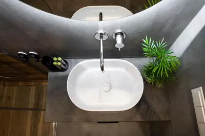 a white sink in a bathroom with a faucet at City Center Sanctuary Modern Business-Class Studio with Free Parking in the Heart of Vilnius in Vilnius