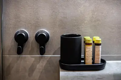 a black holder with four bottles of hair products at City Center Sanctuary Modern Business-Class Studio with Free Parking in the Heart of Vilnius in Vilnius