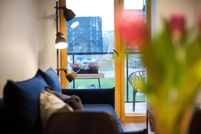 a living room with a blue couch and a window at City Center Sanctuary Modern Business-Class Studio with Free Parking in the Heart of Vilnius in Vilnius