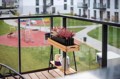 a wooden stand with a plant on a balcony at City Center Sanctuary Modern Business-Class Studio with Free Parking in the Heart of Vilnius in Vilnius