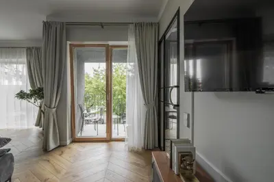 a living room with a large window and a television at IVIS House - Classical Apartment with Balcony in Vilnius Old Town in Vilnius