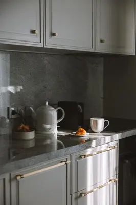a kitchen counter with a teapot and two cups on a counter at IVIS House - Classical Apartment with Balcony in Vilnius Old Town in Vilnius
