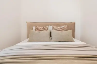 a white bed with four pillows on it at #stayhere - Elegant & Light 1BDR apartment Vilnius Old Town in Vilnius
