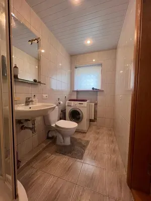 a bathroom with a toilet sink and a washing machine at Kepezinski ECO Apartments in Kaunas