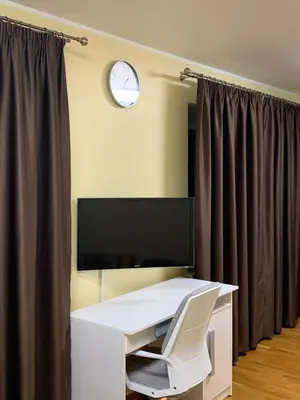 a white desk with a white chair and a clock at Kepezinski ECO Apartments in Kaunas