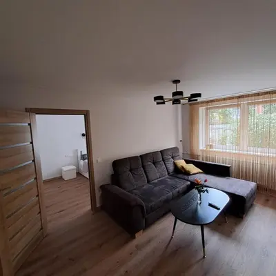 a living room with a couch and a table at Vytės apartamentai in Kaunas