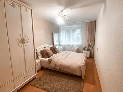 a bedroom with a large white bed and a window at Apartamentai Vytauto Street III in Šiauliai