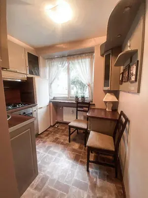 a kitchen with a table and chairs and a window at Apartamentai Vytauto Street III in Šiauliai