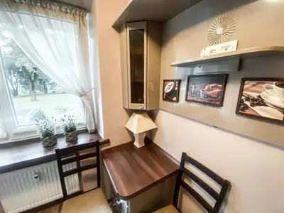 a dining room table with two chairs and a window at Apartamentai Vytauto Street III in Šiauliai