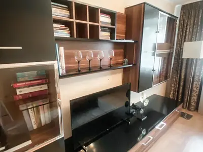a room with a desk and wine glasses on a shelf at Apartamentai Vytauto Street III in Šiauliai