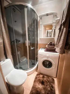 a bathroom with a shower and a washing machine at Apartamentai Vytauto Street III in Šiauliai