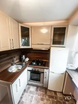 a small kitchen with a sink and a refrigerator at Apartamentai Vytauto Street III in Šiauliai