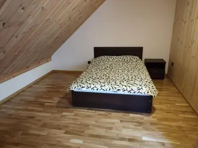 a bedroom with a bed and a wooden floor at Apartamentai Pušyne in Druskininkai