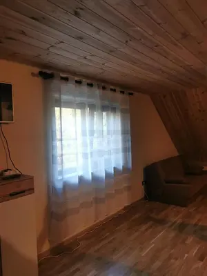 a living room with a window and a couch at Apartamentai Pušyne in Druskininkai