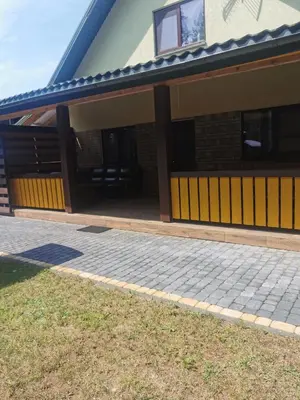 a house with a porch and a patio at Apartamentai Pušyne in Druskininkai