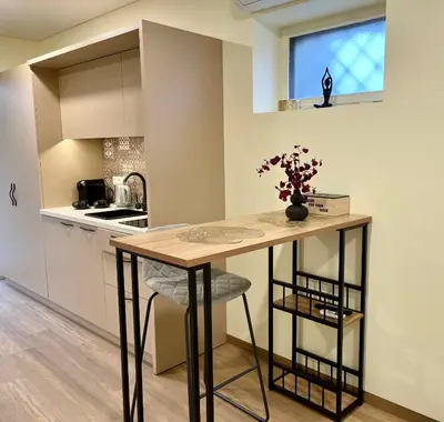 a kitchen with a counter and a table with a vase of flowers at Alanta Apartments Easy Kaunas in Kaunas