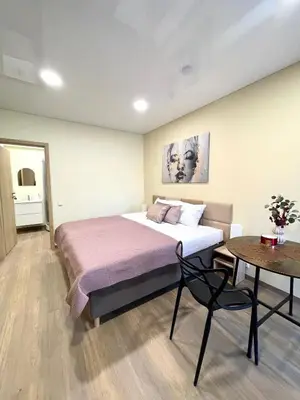 a bedroom with a large bed and a table at Alanta Apartments Easy Kaunas in Kaunas