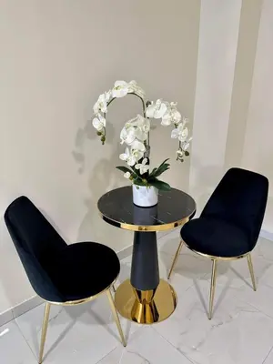 two chairs and a table with a vase of flowers on it at VILA ROŽĖ Nakvynė in Raseiniai