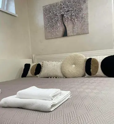 a bed with a pile of towels on it at VILA ROŽĖ Nakvynė in Raseiniai