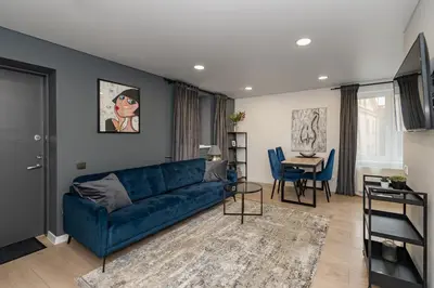 a living room with a blue couch and a table at RIVERFRONT 2BD Old Town Apartment by Domvia in Kaunas