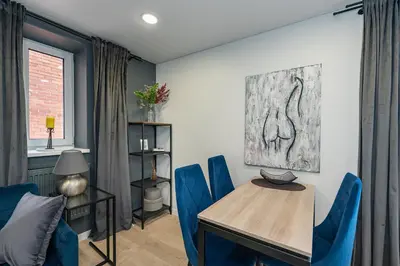 a dining room with blue chairs and a table at RIVERFRONT 2BD Old Town Apartment by Domvia in Kaunas