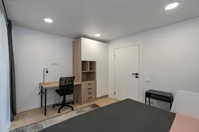 a bedroom with a bed and a desk and a chair at RIVERFRONT 2BD Old Town Apartment by Domvia in Kaunas