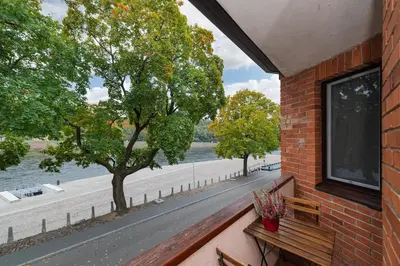 a brick building with a bench and a view of a river at RIVERFRONT 2BD Old Town Apartment by Domvia in Kaunas