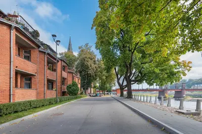 an empty street with a tree in the middle at RIVERFRONT 2BD Old Town Apartment by Domvia in Kaunas