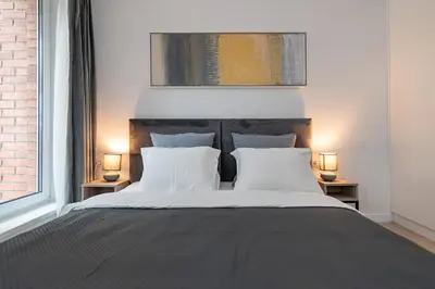 a bedroom with a large bed with two lamps at RIVERFRONT 2BD Old Town Apartment by Domvia in Kaunas