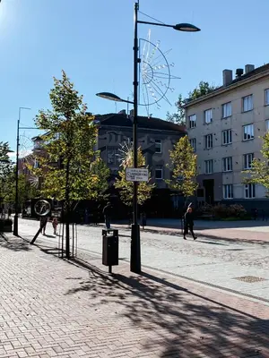 a city street with a ferris wheel in the background at City Central apartament in Šiauliai