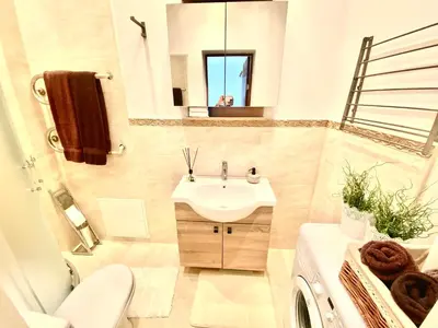 a bathroom with a sink and a toilet and a mirror at City Central apartament in Šiauliai