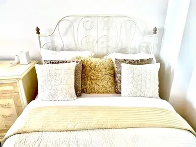 a bed with a white headboard and pillows at City Central apartament in Šiauliai