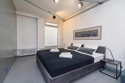 a bedroom with a large bed with two towels on it at Hidden Submarine in Vilnius